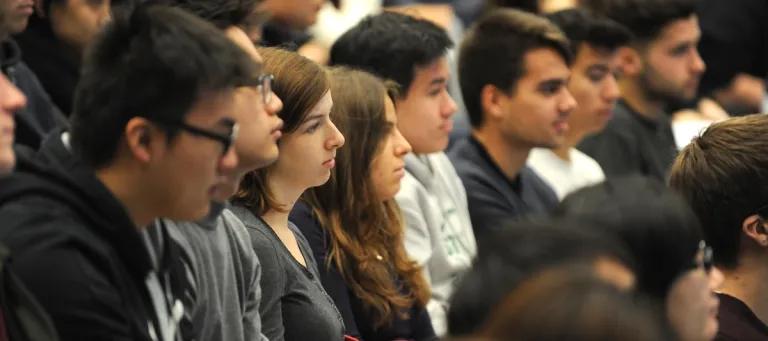 Several students sitting in a lecture theatre listening to a talk